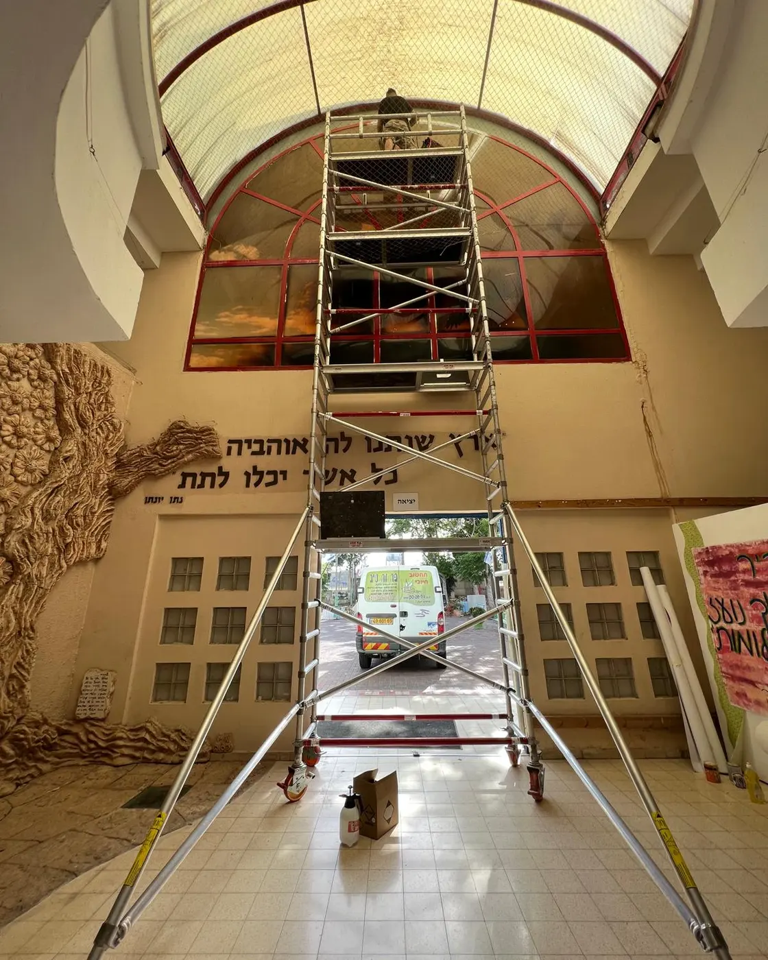 חנן על פיגום גבוה בזמן התקנת הדפסת ענק בכיפת מבנה, אשקלון
